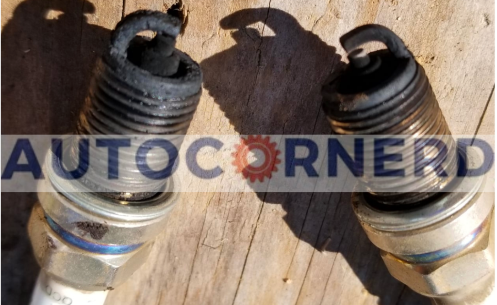 Two used spark plugs with dark deposits around their firing ends.